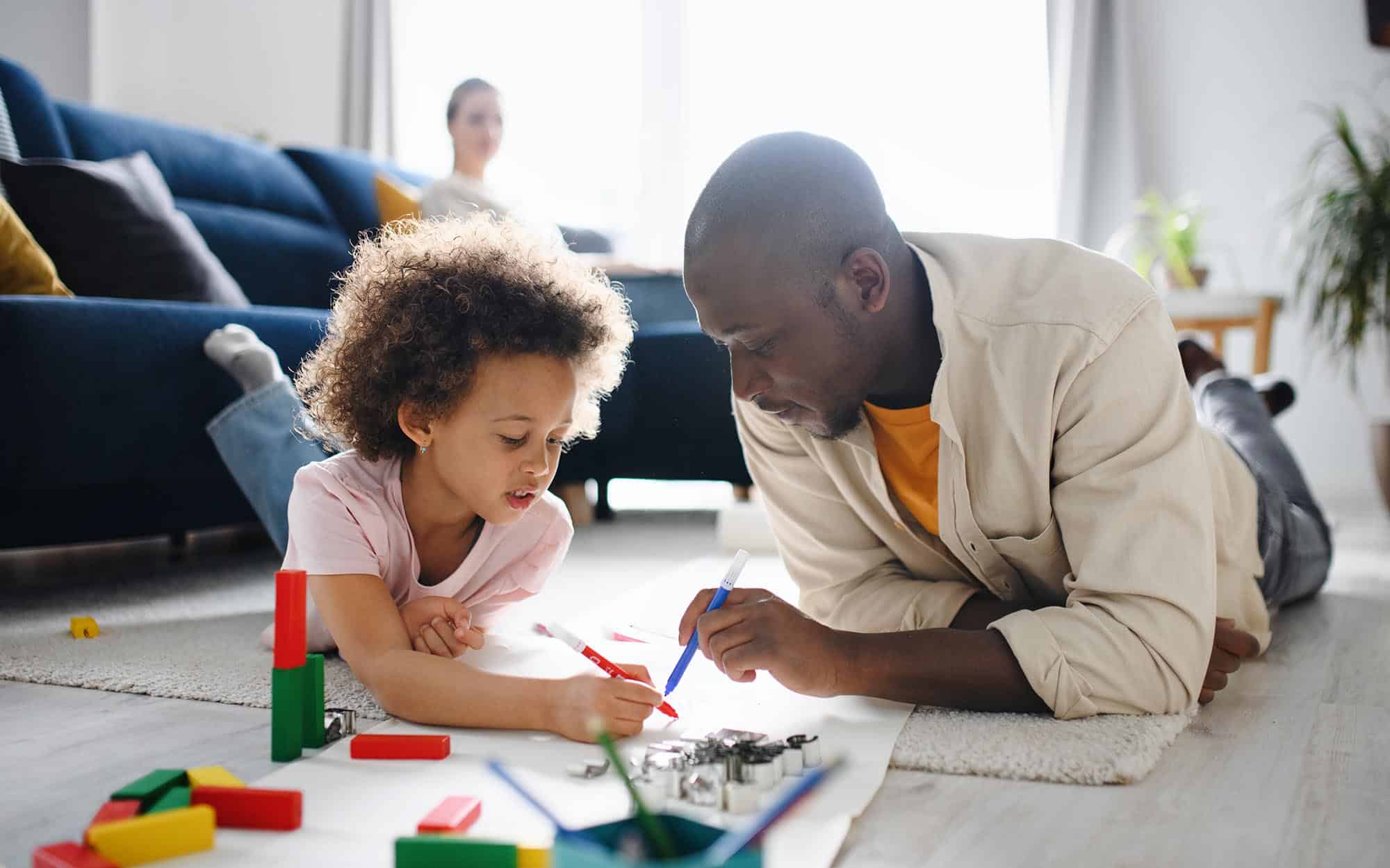 Parent and child working on drawing with markers