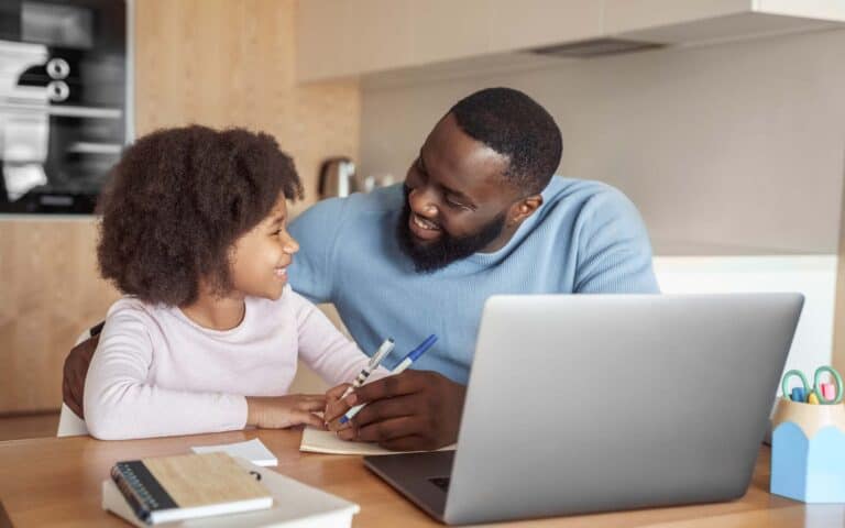 Happy young parent father help child daughter with distance learning from home_