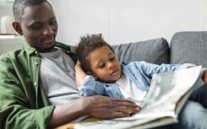 A-parent-and-child-on-couch-reading-a-book-together