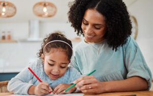 Front view of a mother and her daughter coloring together
