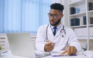 Side view of a doctor looking at a computer