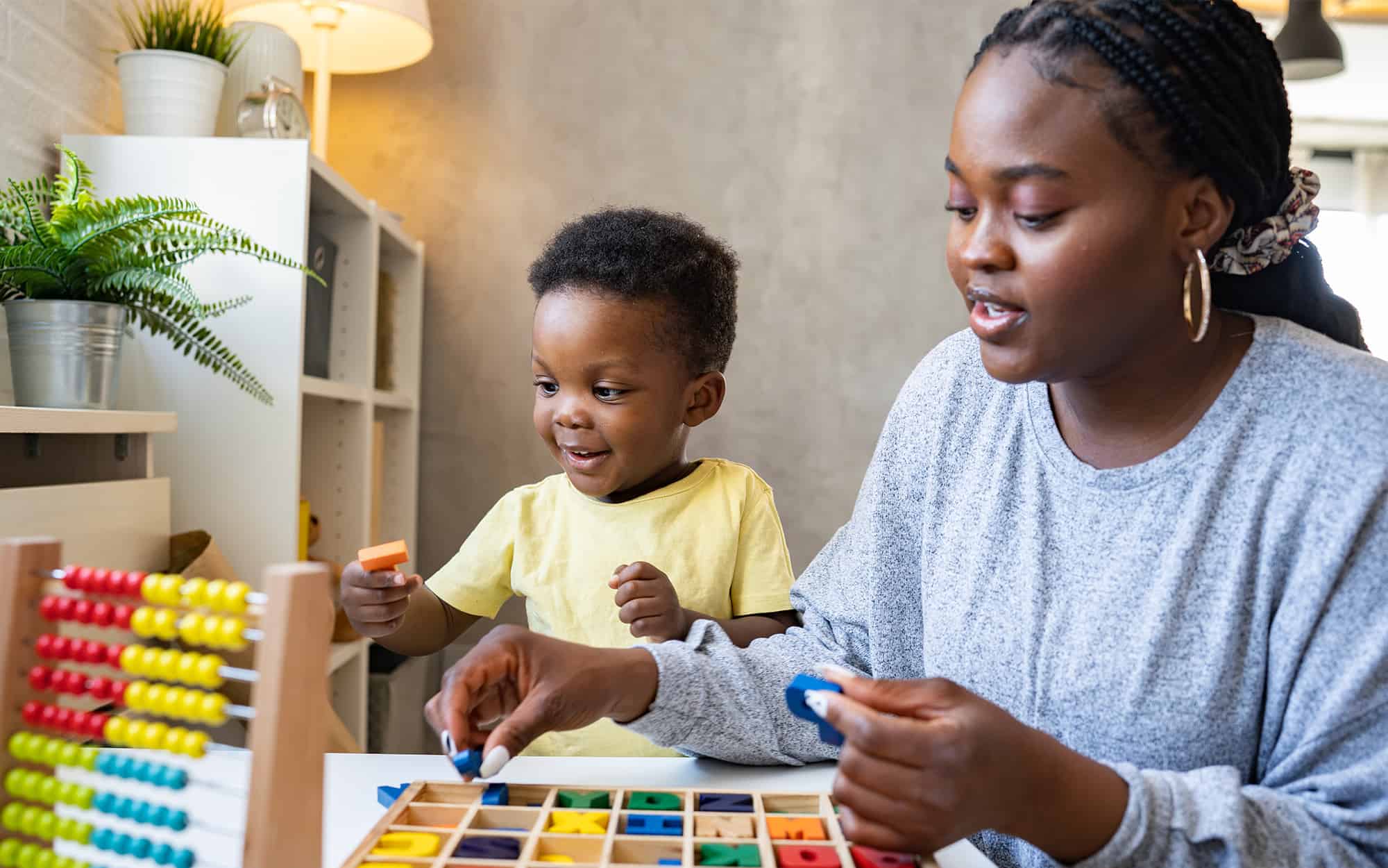 Front view of teacher playing with child using educational toys