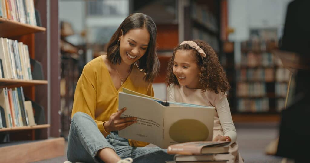 woman with little girl reading a book